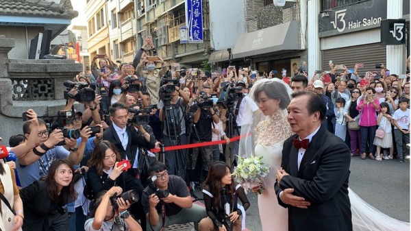 到了“吴氏大宗祠”,“志玲姐姐”身穿白色镂空珍珠坠饰礼服，爸爸林繁男挽着她一同登场。