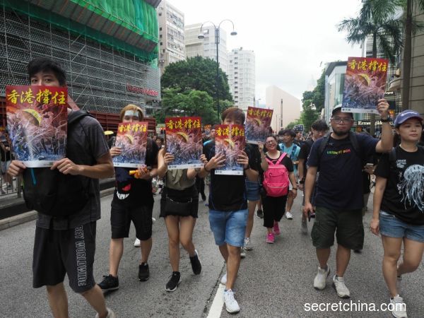 7月7日，23万香港人参加了九龙“反送中”游行，游行人士手持《看中国》印刷的“香港撑住”画报。