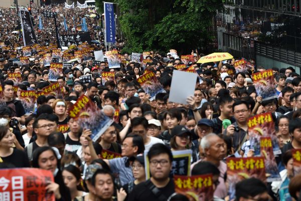 7月7日，23万香港人参加了九龙“反送中”游行，游行人士手持《看中国》印刷的“香港撑住”画报。