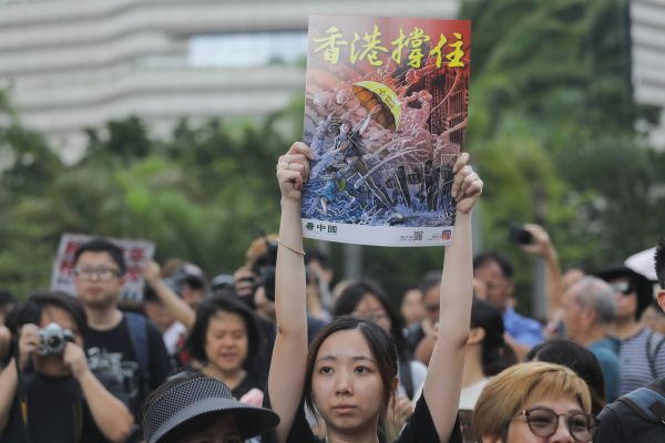 7月7日，23万香港人参加了九龙“反送中”游行，游行人士手持《看中国》印刷的“香港撑住”画报。