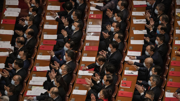 在两会上鼓掌的代表们。（图片来源：Kevin FrayerGetty Images）