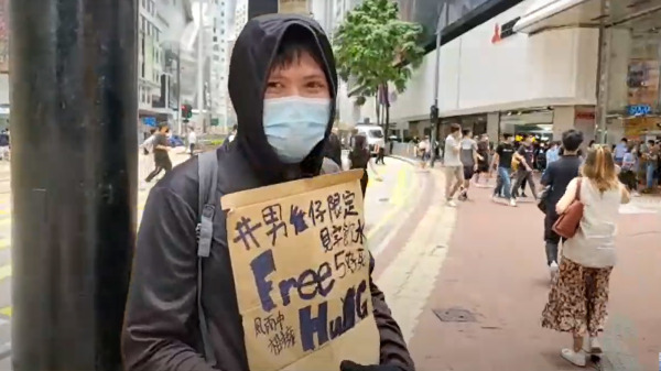 化名为LS的男青年在现场举牌提供“Free Hug”（免费拥抱），牌上写着“风雨中相接”、“见字饮水不要死”等字句。