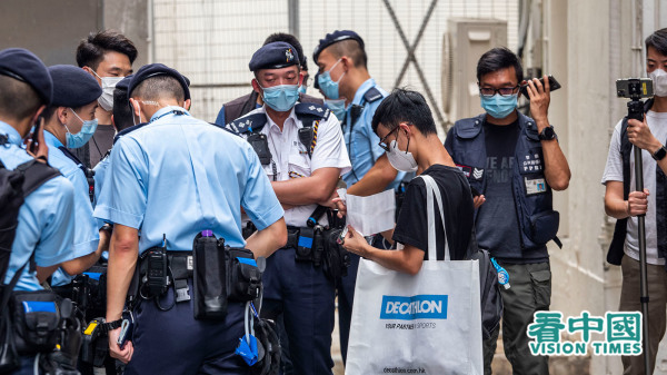 身穿黑衣的男青年被军装警员包围、截查。（图片来源：李天正/看中国）