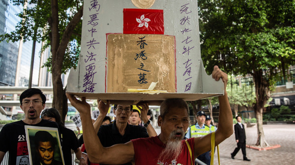 图为2015年7月1日，古思尧高举香港之墓抗议。（图片来源：Getty Images）