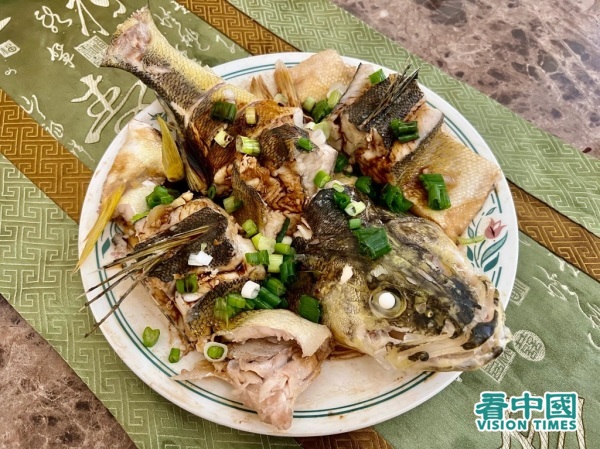 淋生抽、料酒出锅后去掉旧姜葱，撒新鲜葱花。（摄影：李青城/看中国）