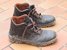 Muddy leather shoes on tile floor