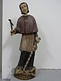 Cette statue polychrome non datée, inspirée le l'iconographie dominante du saint remplace l'aumusse par le camail, obtenu par les chanoines en 1674.