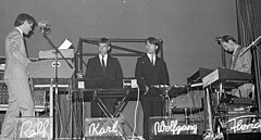 The five members of the electronic band Kraftwerk performing on a stage