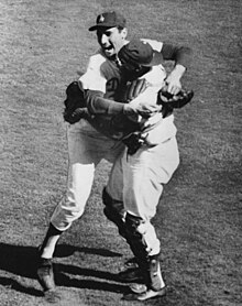 "Two baseball players jumping and hugging each other in celebration."