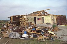 A heavily damaged home with much of its brick exterior and roof destroyed