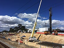 crane and pile driver viewed from station platform