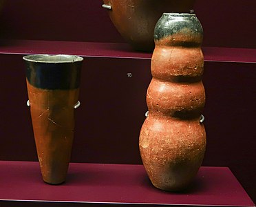 Vases de type cornet et à panse ondulée. Terre cuite à panse rouge et col noirci. Musée des Confluences