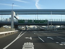 Highway junction in daylight with an exit to the left