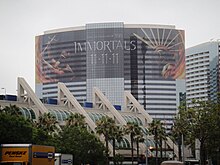 Photographie en couleurs montrant la façade vitrée d'un hôtel recouverte d'une publicité semi-transparente pour Les immortels.