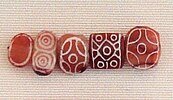 Indian carnelian beads with white design, etched in white with an alkali through a heat process, imported to Susa in 2400–2100 BC. Found in the tell of the Susa acropolis. Louvre Museum, reference Sb 17751.[65][66] These beads are identical with beads found in the Indus Civilization site of Dholavira.[67]