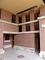 Stairway to kitchen at right, door to former boiler room at center as seen from motor court