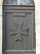 Croix de Malte sculptée sur la porte de la chapelle Saint-Roch.