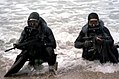 SEALs con traxes de buzu remaneciendo del océanu.