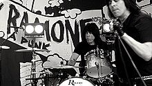 Marky on drums with Ken Stringfellow singing into a microphone