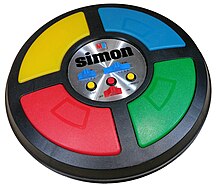 The game is a circular disc divided into four quarter circle buttons each with a different color. In the center are the game mode controls