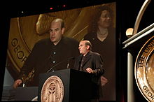 Photo de David Simon donnant un discours derrière un pupitre.