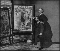 Zidler's assistant and Moulin-Rouge manager, Tremolada, pointing at Jules Chéret's 1889 poster, Bal du Moulin Rouge with Toulouse-Lautrec, Place Blanche, Paris, 1892[6]