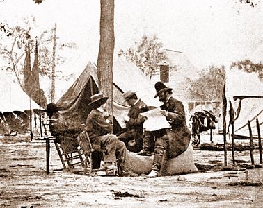 Brady (centro, usando chapéu de palha), com General Ambrose Burnside (lendo jornal), tirada em maio de 1864