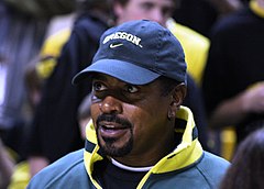 Candid head and shoulders photograph of Rashad wearing a baseball cap bearing the Oregon Ducks logo