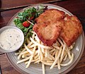 Schnitzel ayam dengan kentang goreng dan salad