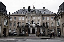 photograph of a large three-story manor house with iron railings