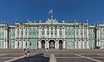 Baroque palace with green and gold facade and a Russian flag on the top