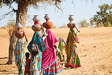 Women with children returning home after fetching water