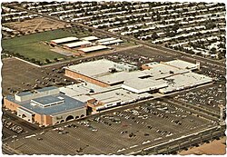 An aerial image of Tri-City Mall in Mesa, Arizona, showing the mall structure and its surrounding parking lot.