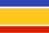 Drapeau composé de 5 bandes horizontales : large bande jaune au centre, encadrée de fines bandes blanches, puis bande moyenne bleue en haut, et également moyenne bande rouge en bas.