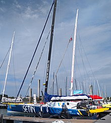 Vu de trois quarts arrière, bateau bleu amarré au ponton.