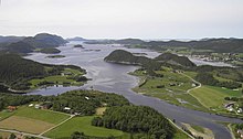 Foto eines Fjords in hügliger Landschaft