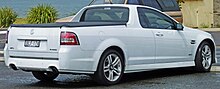 Rear three-quarters view of a white low coupe utility vehicle with two doors