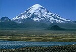 A snow-covered mountain peak, river in front