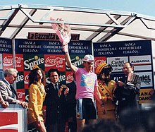 A man holding flowers while wearing a pink jersey.