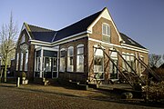 Hetzelfde café in 2014. Het pand wordt gestut in verband met scheuren als gevolg van bodemdaling door aardgaswinning