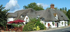 English pub names such as The Barley Mow (like this pub at Clifton Hampden) allude to the use of barley to make the beer available inside.[94]