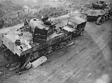 Two damaged tanks with their tracks visibly destroyed and a damaged Willy's Jeep displaying the 6th Armoured triangular flash