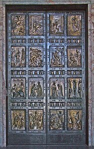 A pair of bronze doors divided into sixteen panels containing reliefs depicting scenes mainly from the life of Jesus and stories that he told.