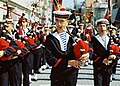 Banda de música da mariña francesa con gorro, pescozo azul, chaqueta azul e camiseta a raias.