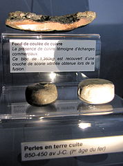 Fond de coulée de cuivre et perles de pierre.