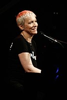 Annie Lennox vừa biểu diễn đàn piano vừa mỉm cười