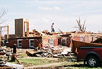 A few parts of affected buildings are left standing. Well-built structures lose all outer and some inner walls. Unanchored homes are swept away, and homes with poor anchoring may collapse entirely. Trains and train cars are all overturned. Small vehicles and similarly sized objects are lifted off the ground and tossed as projectiles. Wooded areas suffer an almost total loss of vegetation and some tree debarking may occur.