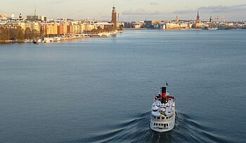 Vänster bild: Vy över Riddarfjärden mot öst från Västerbron. Till vänster ligger Kungsholmen, rakt fram syns Stockholms stadshus och till höger därom Riddarholmen. I förgrunden stävar ångfartyget M/S Gustafsberg VII in mot Stadshuskajen. Höger bild: Vy mot väst från Centralbron med fritidsbåtar som just lämnade Karl Johansslussen. Längst till höger syns Stockholms stadshus och i bakgrunden skymtar Västerbron.