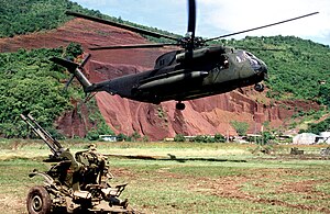 En CH-53D Sea Stallion-helikopter ur amerikanska marinkåren svävar över marken i närheten av ett sovjetisk ZU-23 luftvärnspjäs under invasionen.