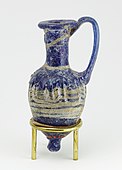 Ancient Egyptian perfume vase in shape of an amphoriskos; 664–630 BC; glass: 8 cm × 4 cm (3.1 in × 1.6 in); Metropolitan Museum of Art (New York City)